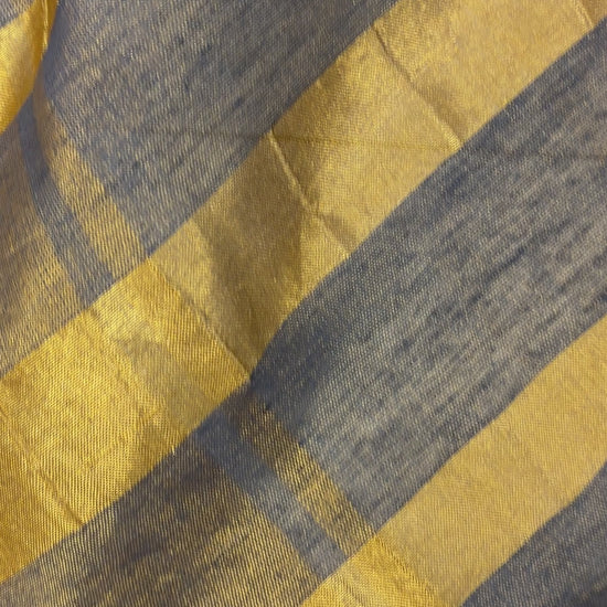 Woman wearing Khadi Tissue Saree in golden tones, exuding festive elegance and grace