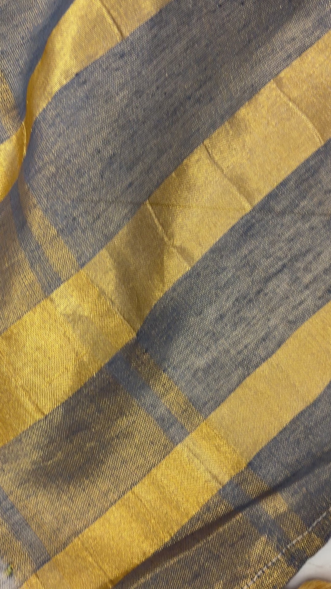 Woman wearing Khadi Tissue Saree in golden tones, exuding festive elegance and grace